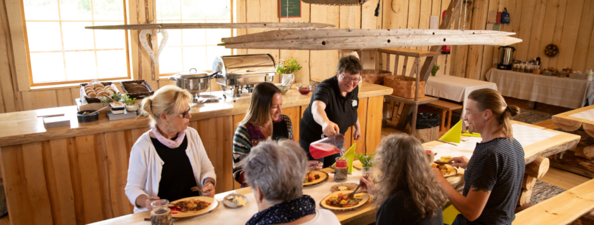 Aholafarmin emäntä tarjoilemassa asiakkailleen